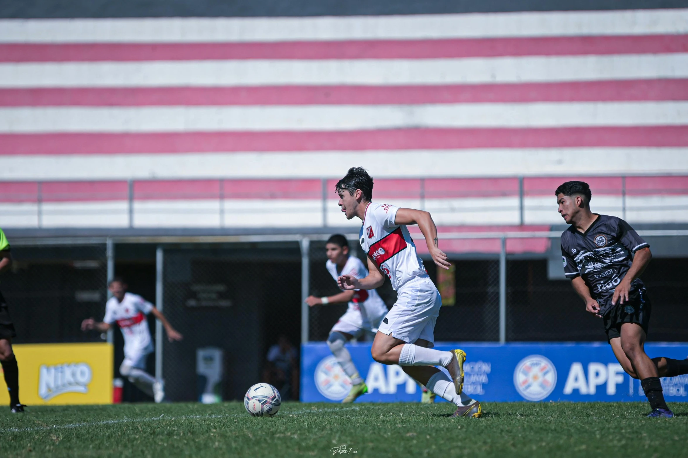 three people are playing soccer in the grass