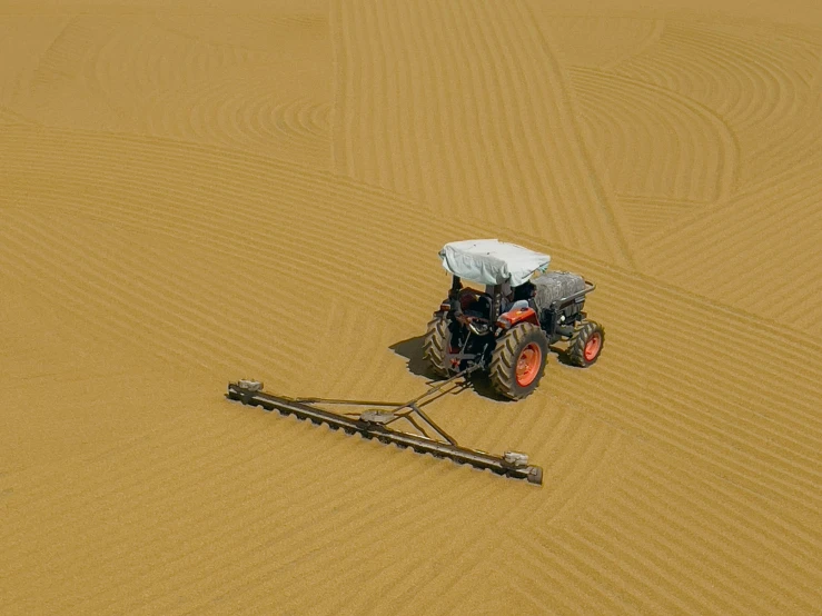 there is a tractor with a cover on driving through the desert