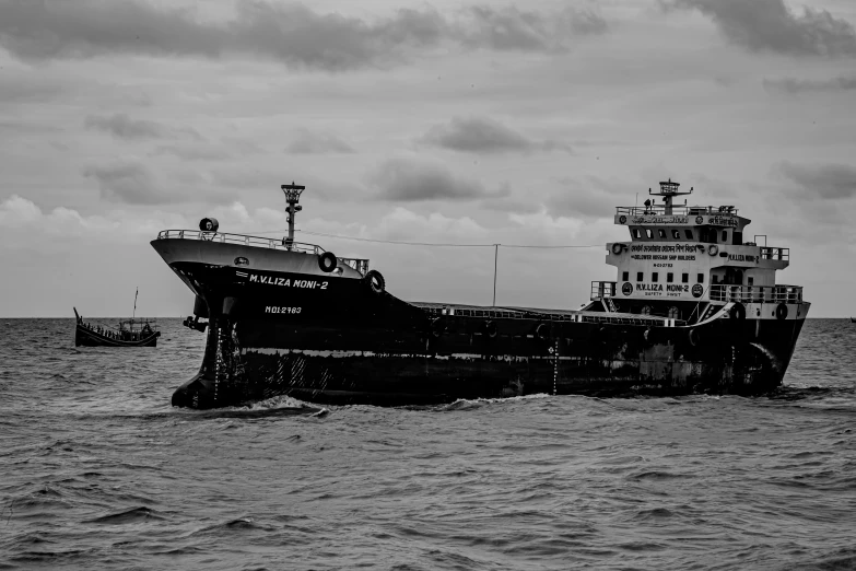 a ship sailing in the water with one boat behind it