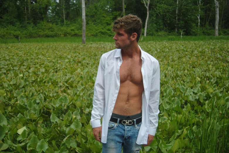 there is a shirtless man standing in a field