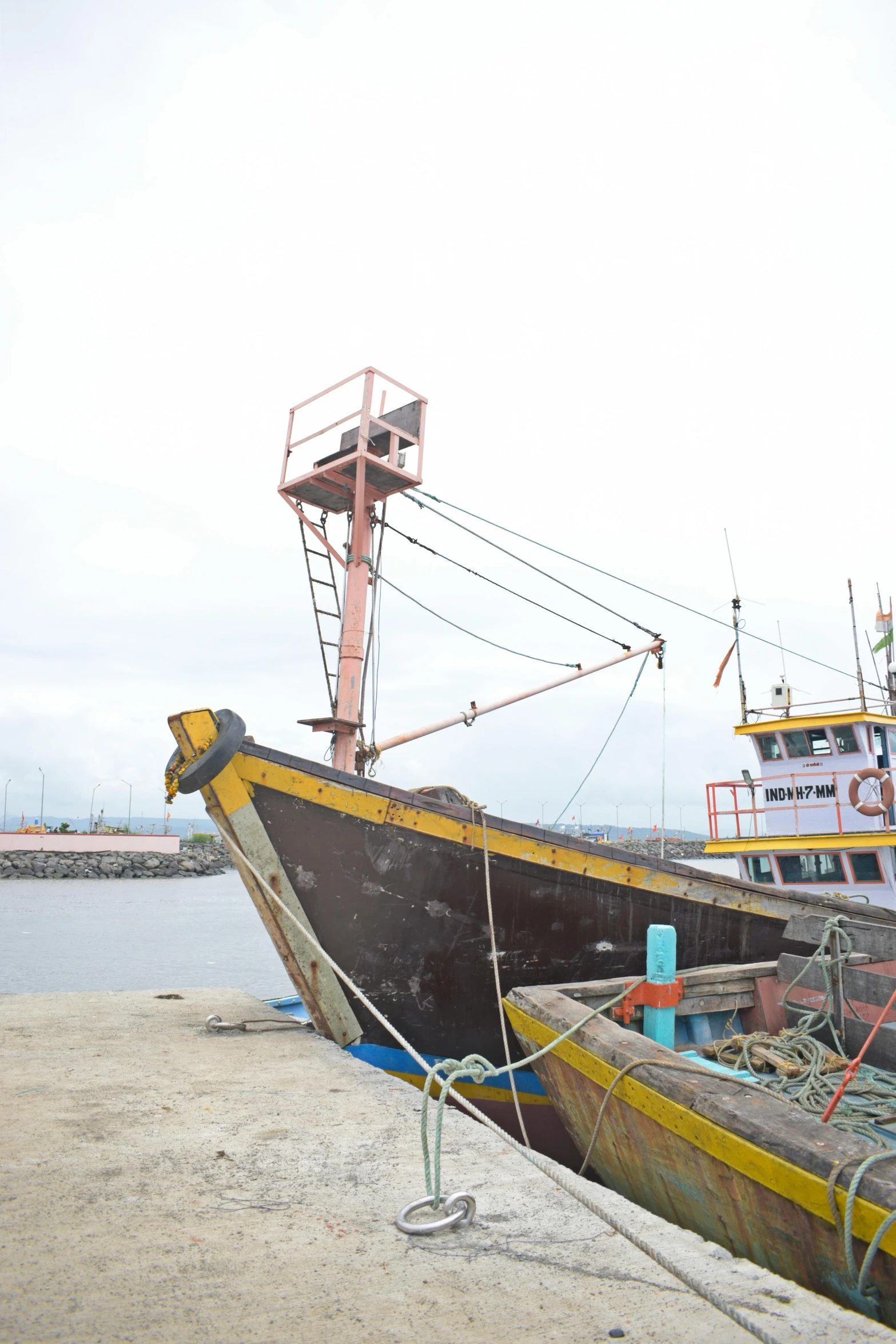 two boats tied to a beach next to a pier