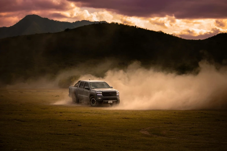 a grey vehicle moving through the dust in the sun