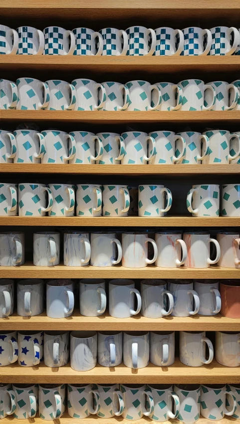 many tea cups in wooden shelves on display