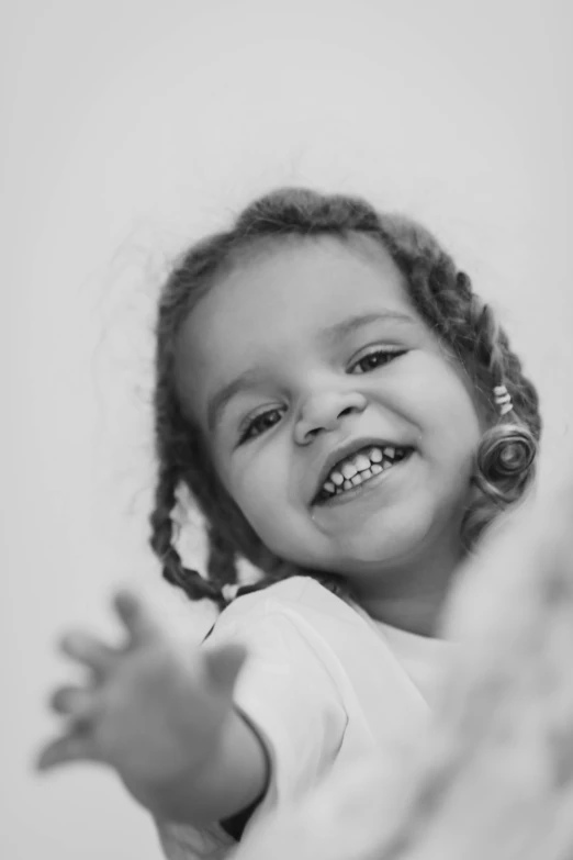 a little girl smiling and wearing a white top