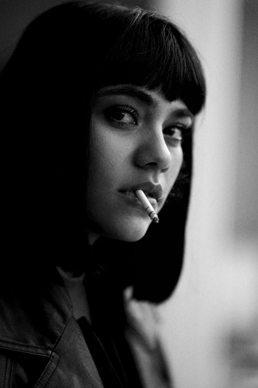 a woman standing and smoking a cigarette in black and white