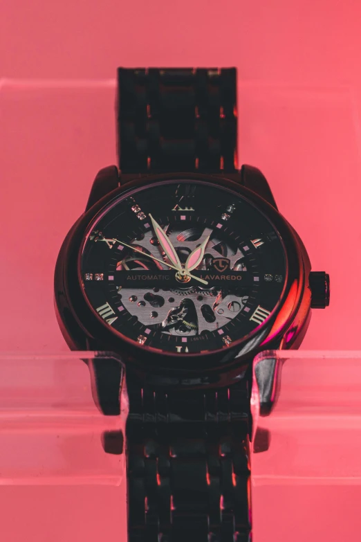 a watch that is sitting on some type of black metal piece