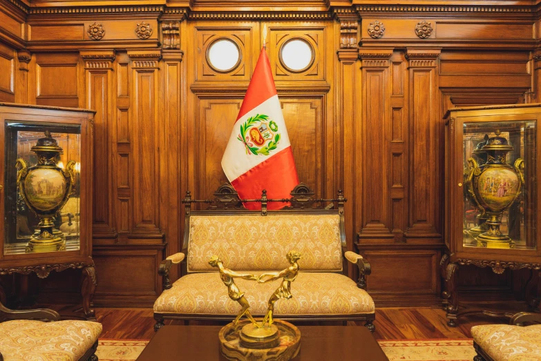 an ornate wooden room with gold chairs and mexican flag