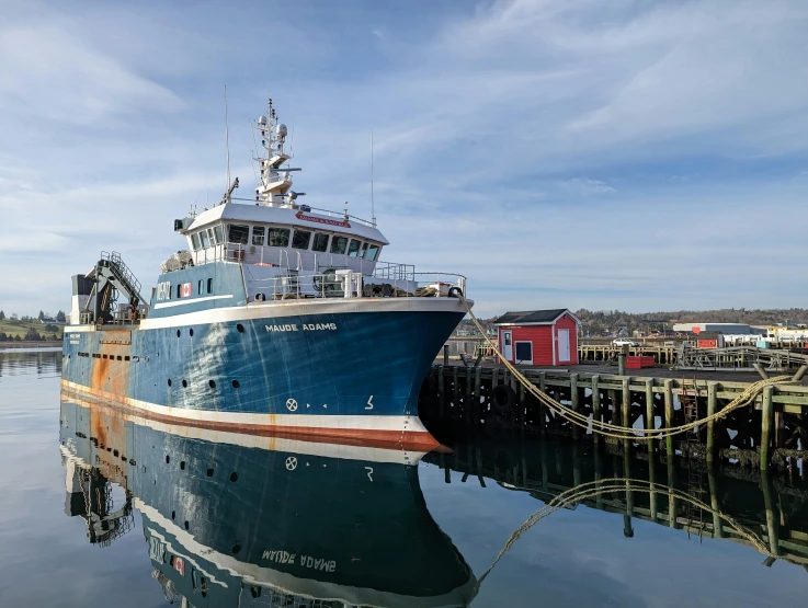 a large ship in the water near a pier