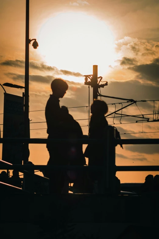 two people sitting near each other at sunset