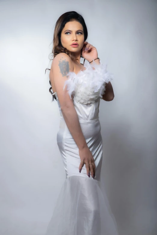 a woman wearing white is posing in her wedding gown