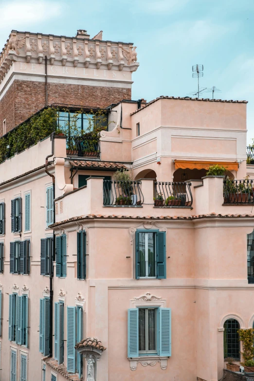 two row houses with balconies and windows with blue shutters