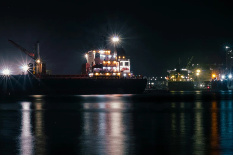 a large ship docked at night with its lights on