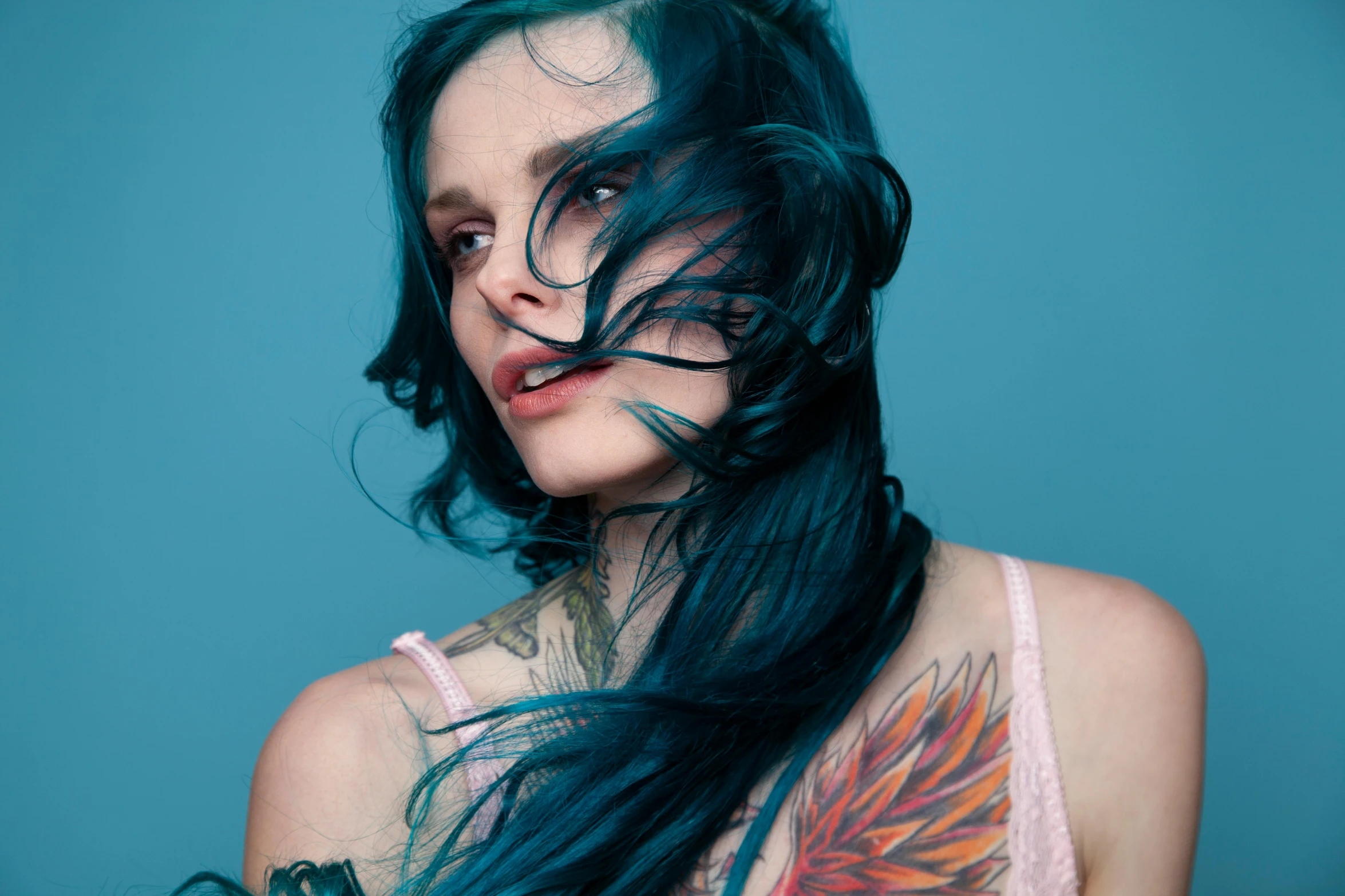 a girl with long hair and piercings, in a tank top