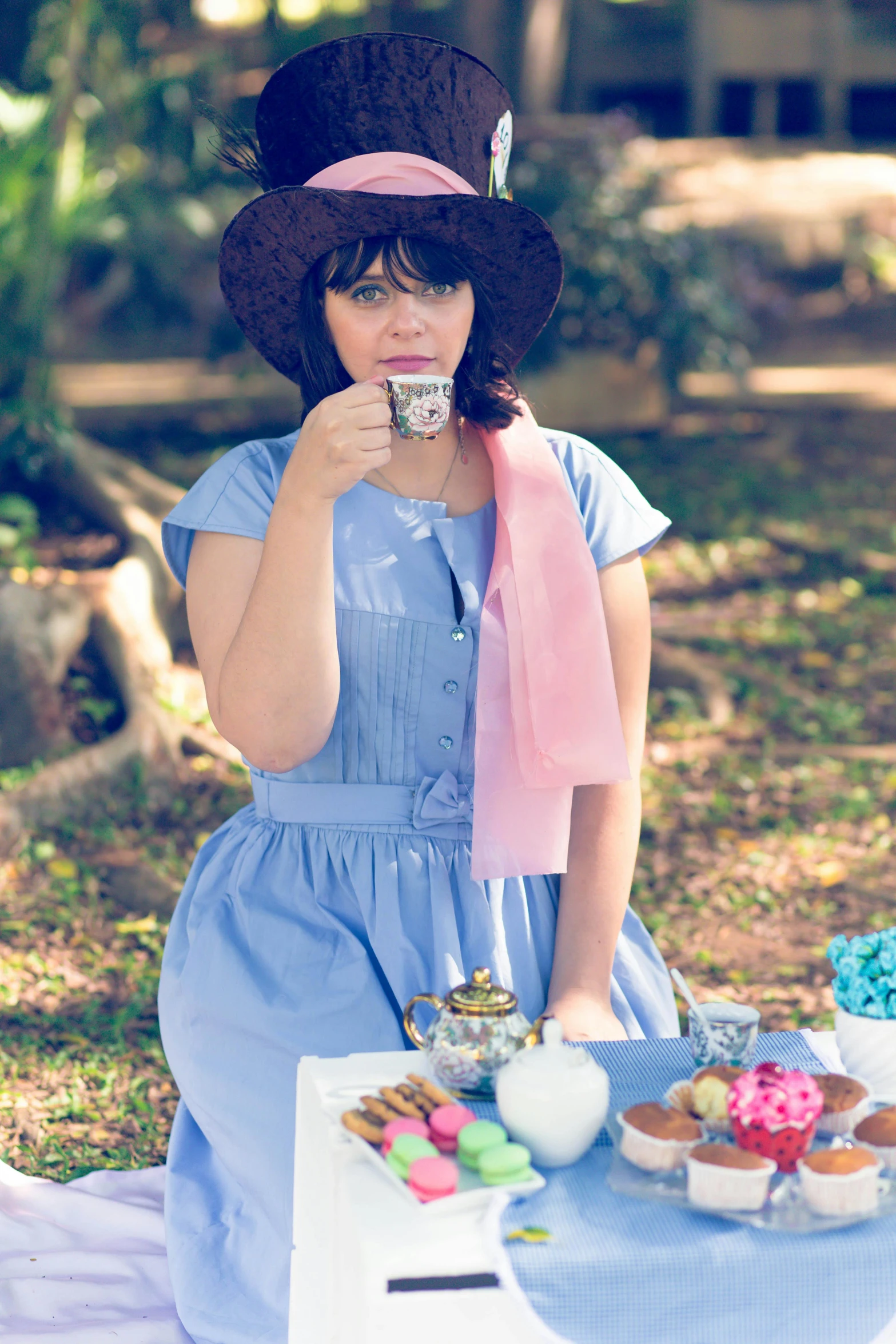 a woman wearing a sun hat eating a doughnut