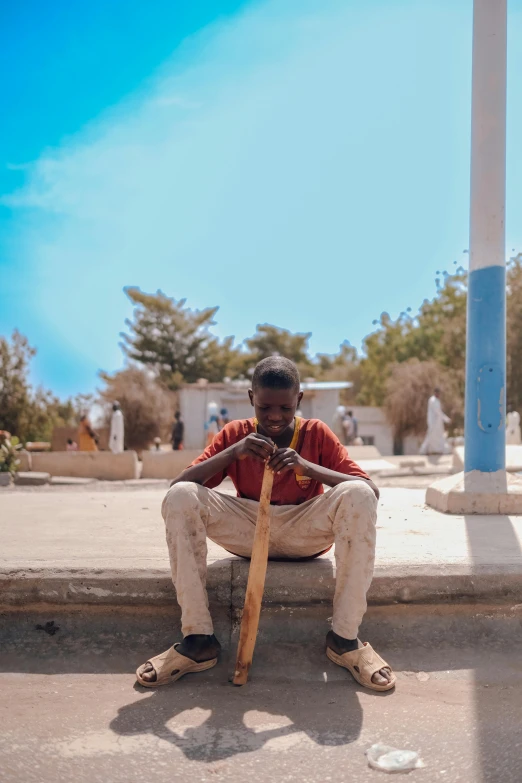 a man sits down with his baseball bat on the ground