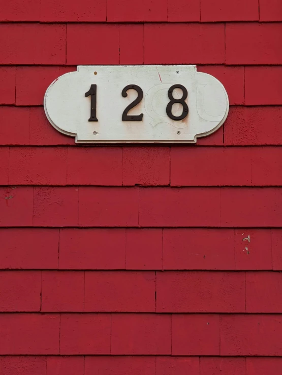 a large white plate mounted to a red building