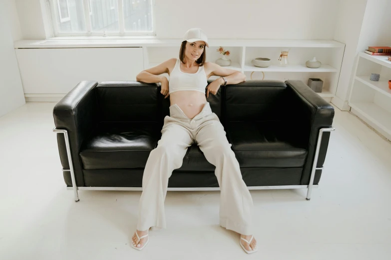 a pregnant woman poses on her couch for a portrait