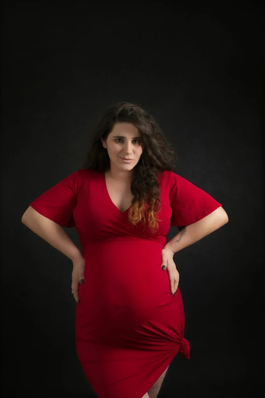 a pregnant woman is posing for the camera