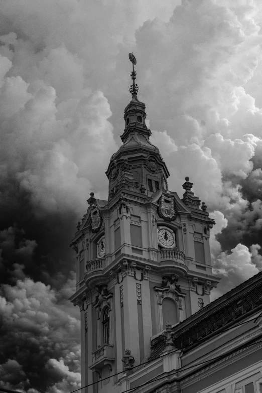 a black and white po of an old building with clouds coming in