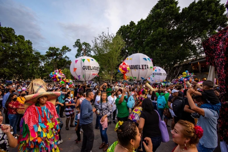 a number of people with large kites in the shape of balloons