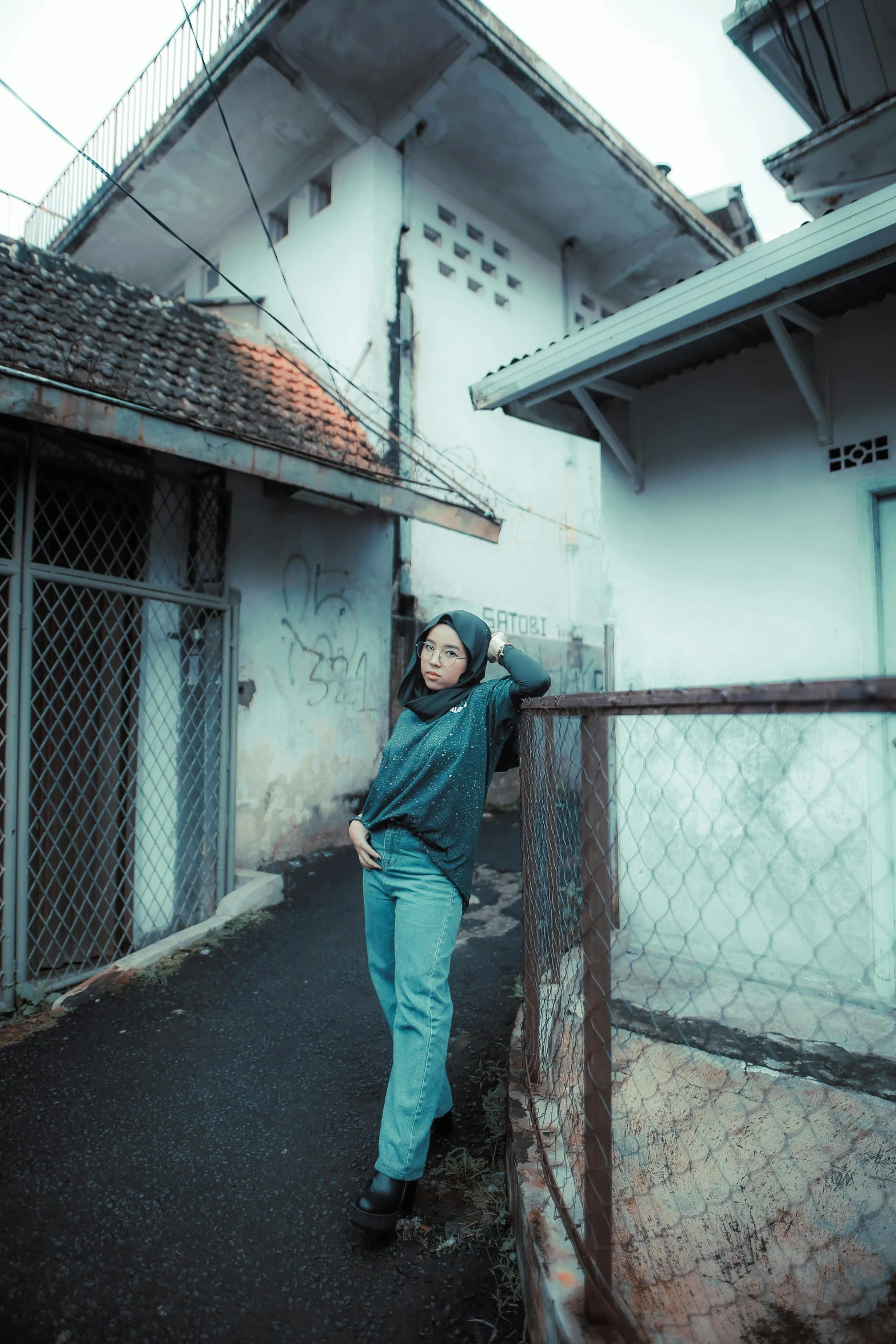 a person leaning on a fence in the middle of a street