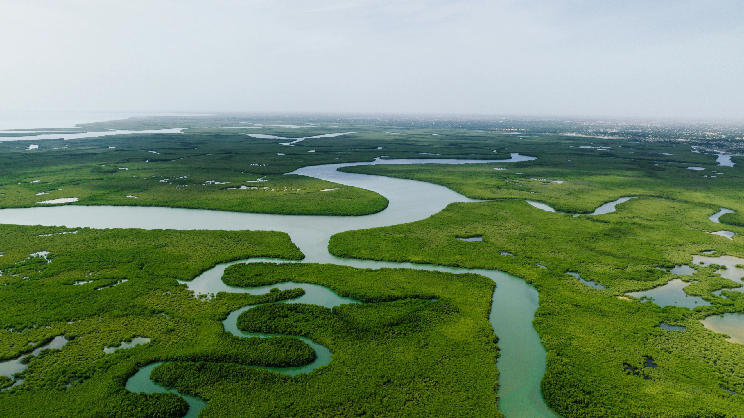 a long stretch of water surrounded by green land