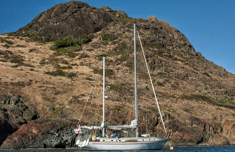 a yacht floating in front of a mountain