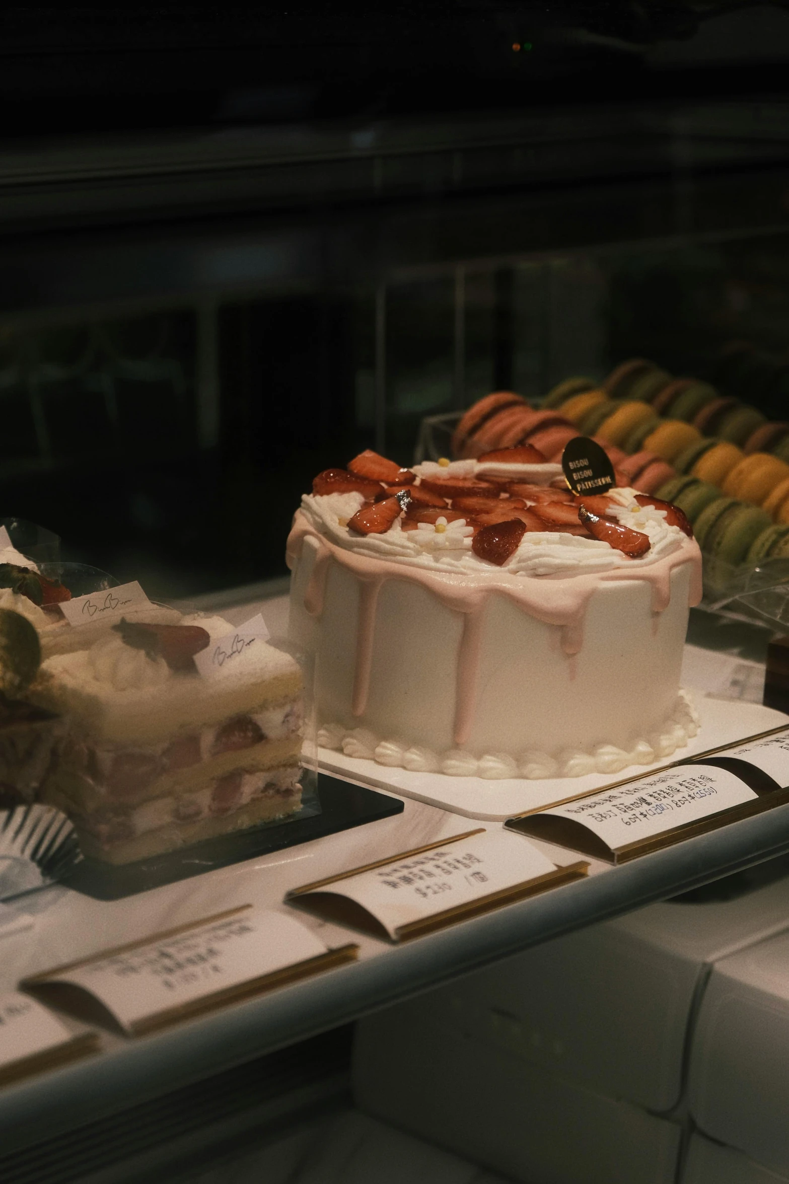 a cake on a counter, with other desserts behind it