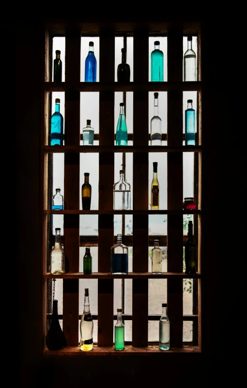 bottles are lined up behind a glass window