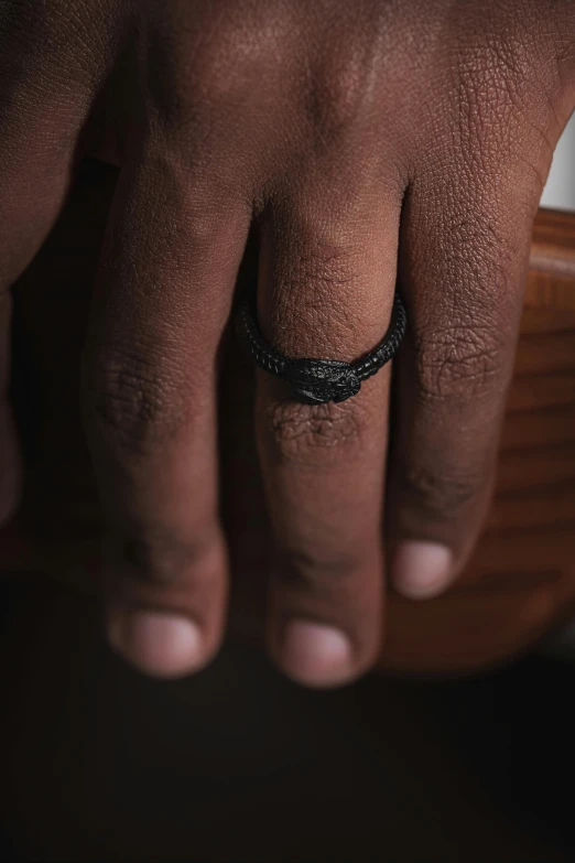 a close up of a person's hand wearing a wedding ring