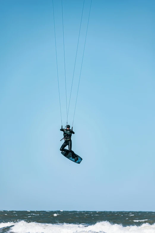 man on surfboard being hoisted in the air