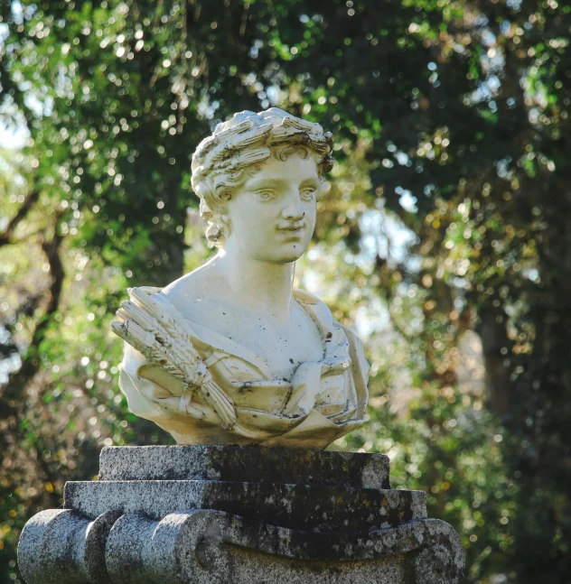 a statue of a woman sitting on top of stone