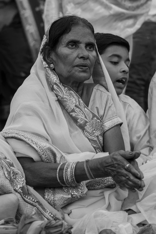 an older woman with two younger women, wearing traditional outfits