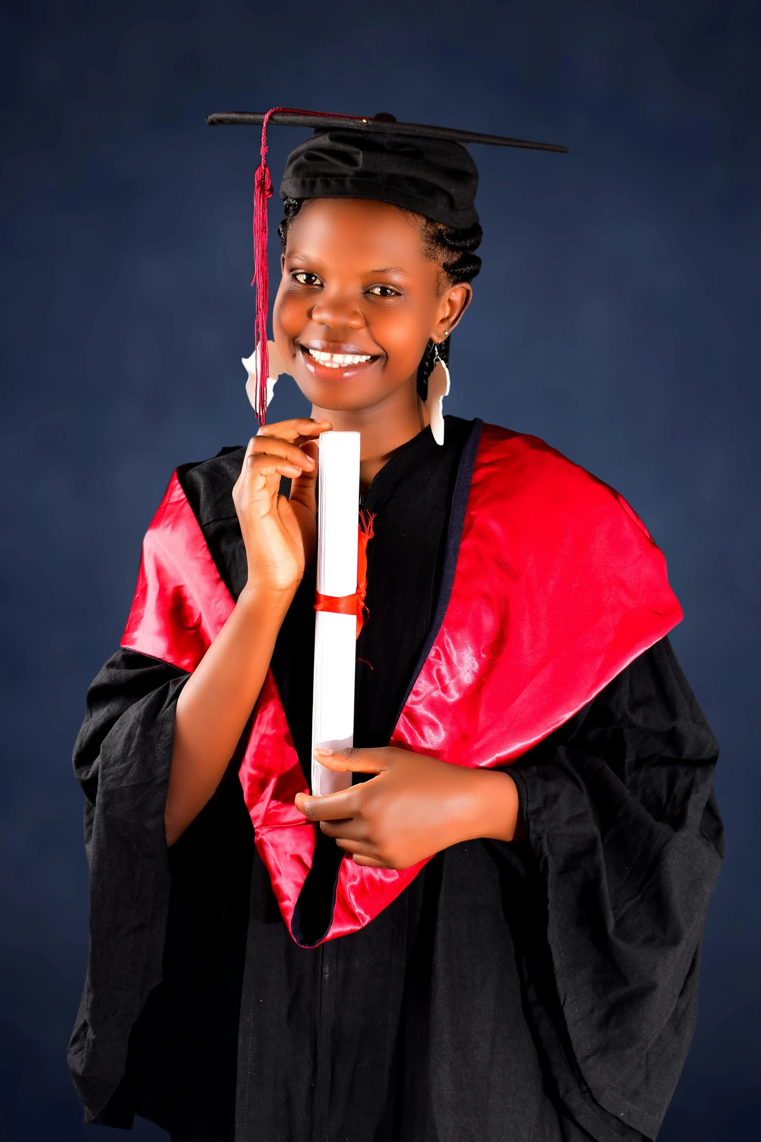 a young woman in graduation robes and holding a diploma