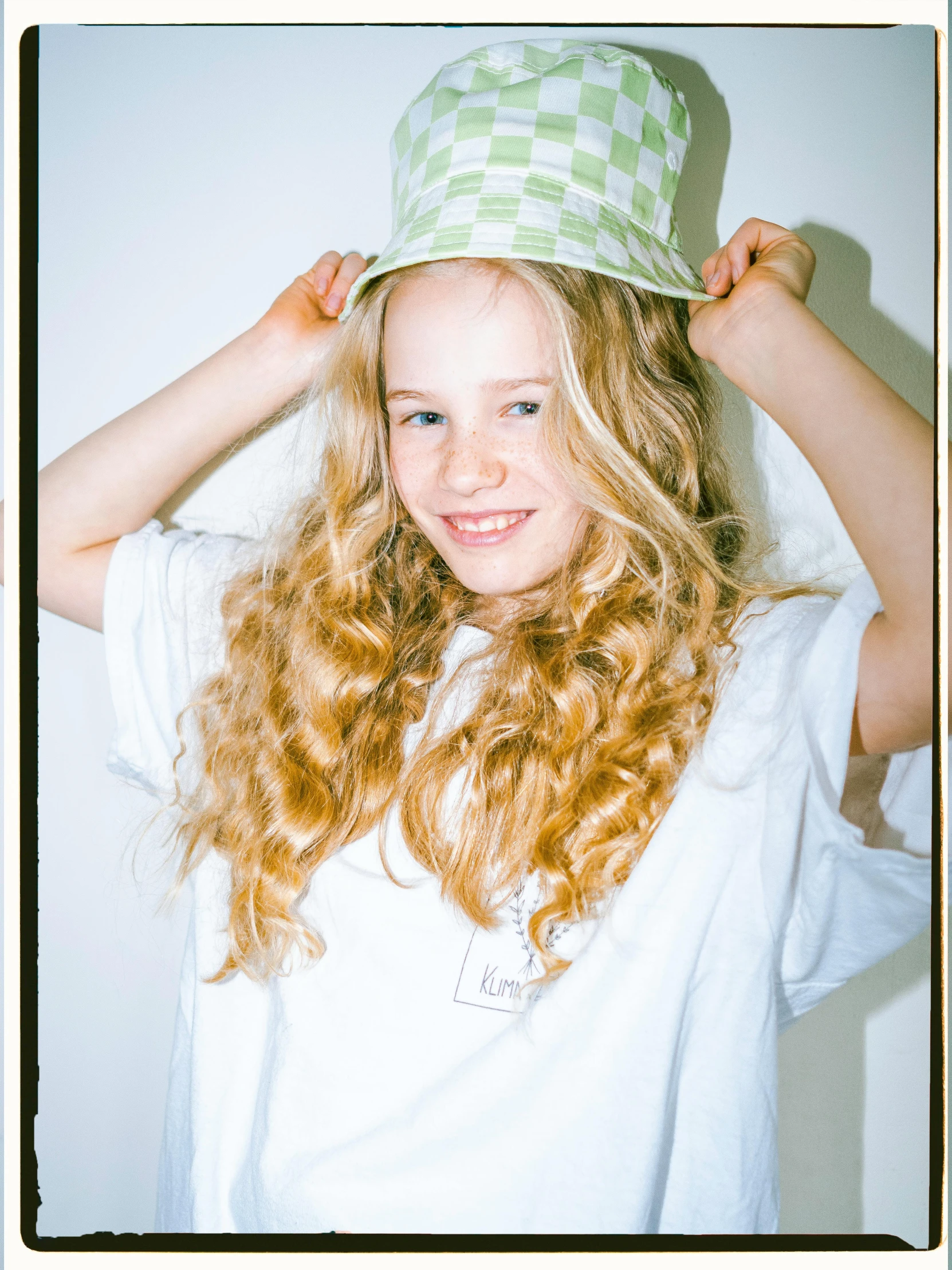 a child is wearing a green hat with white stripes on it