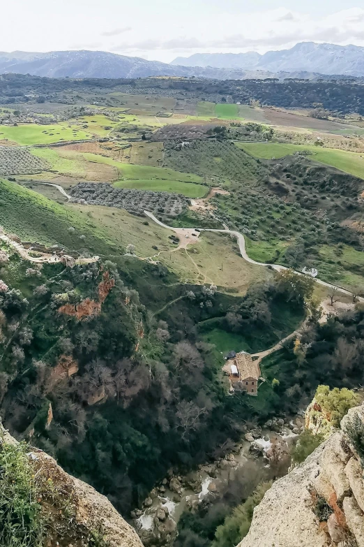 the view of a valley from a small peak