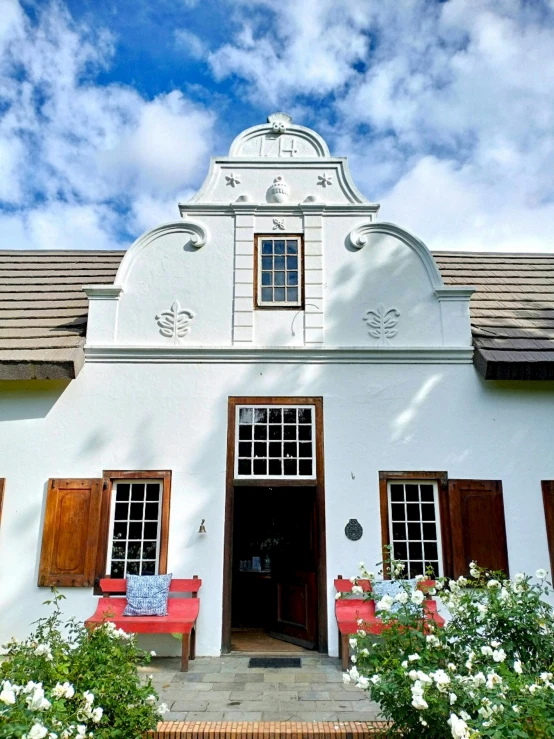 a white building has many large wooden doors and windows