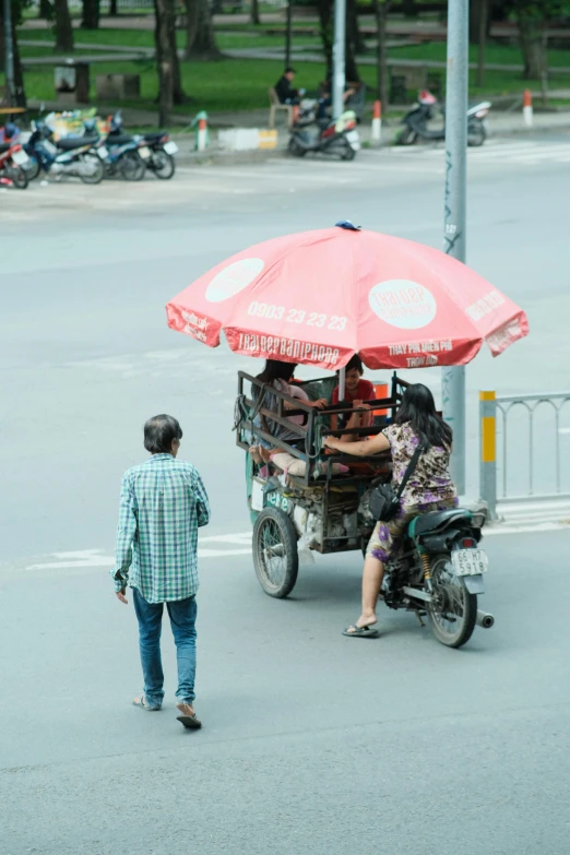 a man that is standing in the street next to a motor cycle