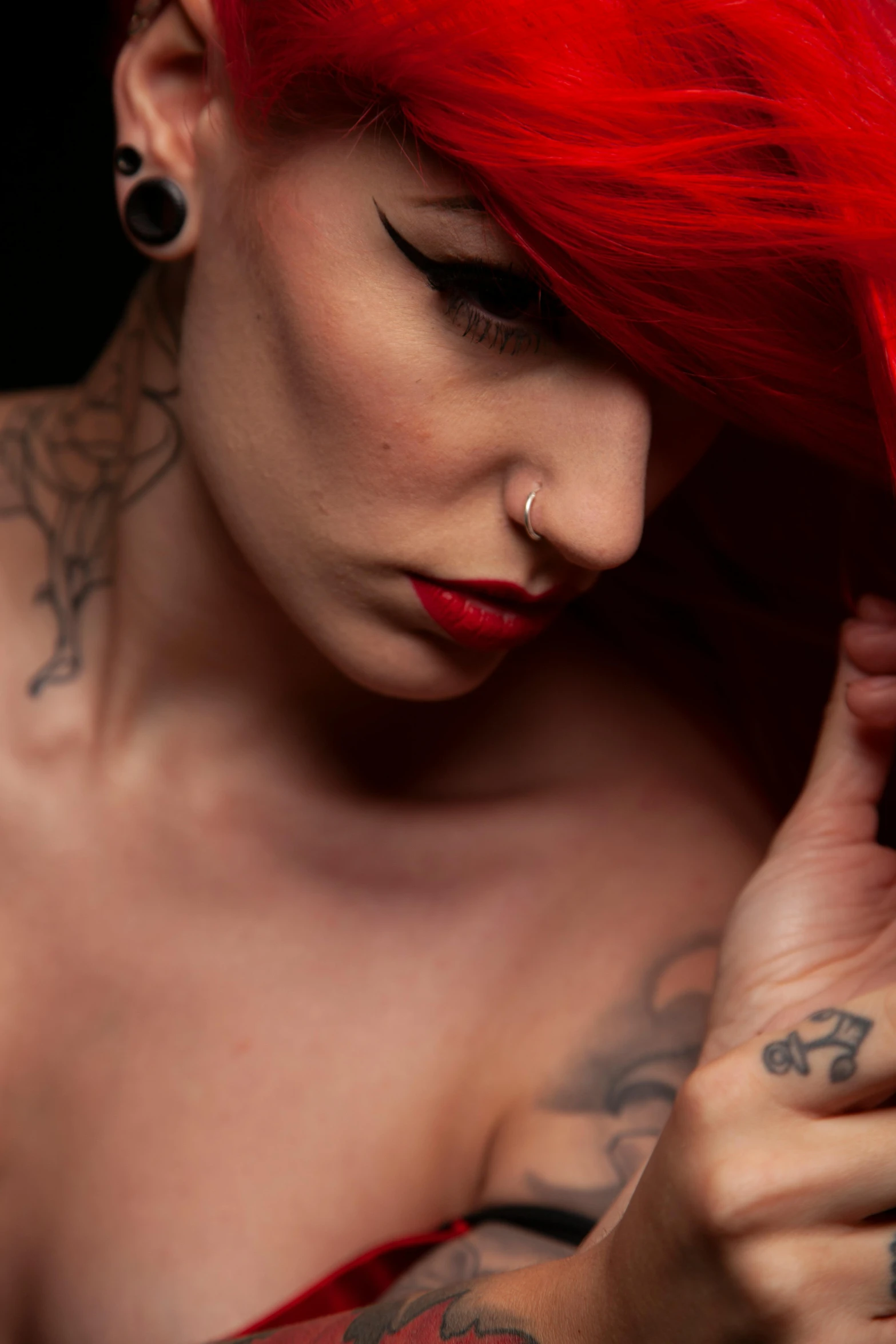 the woman has red hair and piercings on her ear
