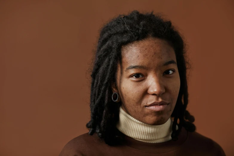 a woman with dreadlocks is staring to the right