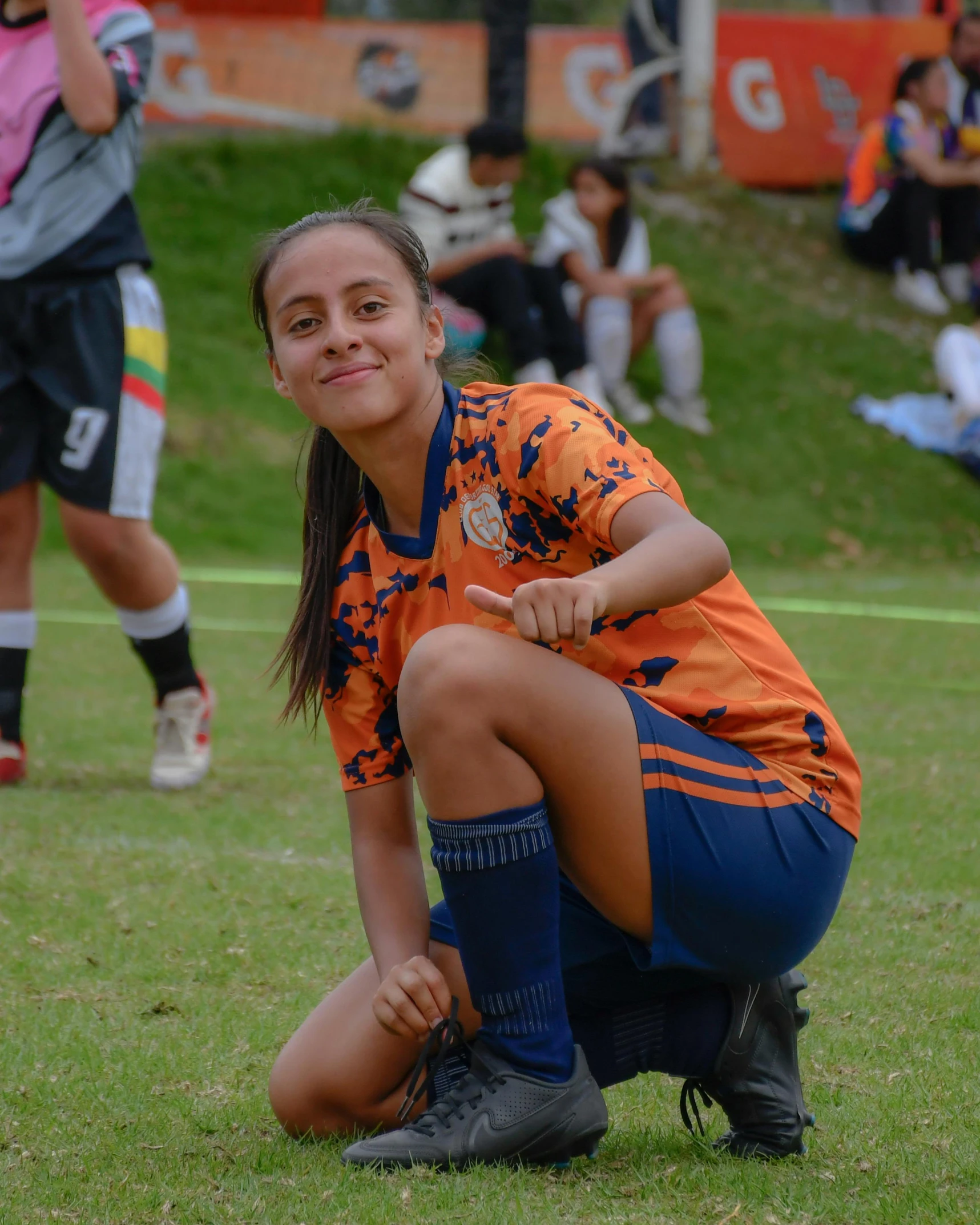 a smiling girl with her hand on her knees