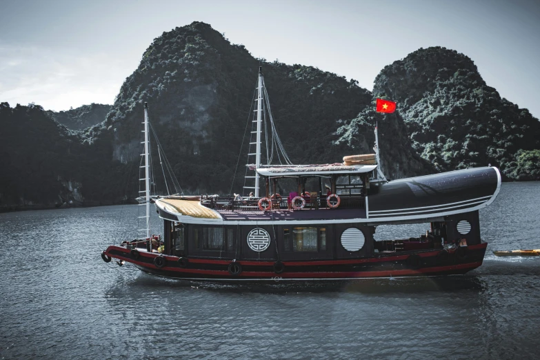 a boat is cruising on the water near some mountains