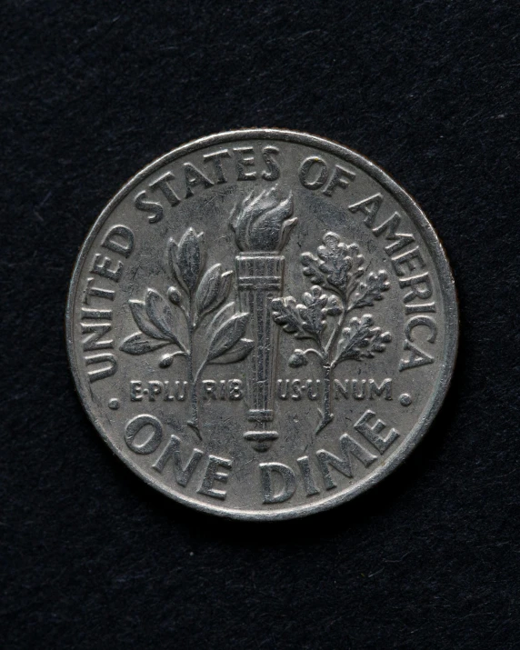 an old silver coin on display on a black surface