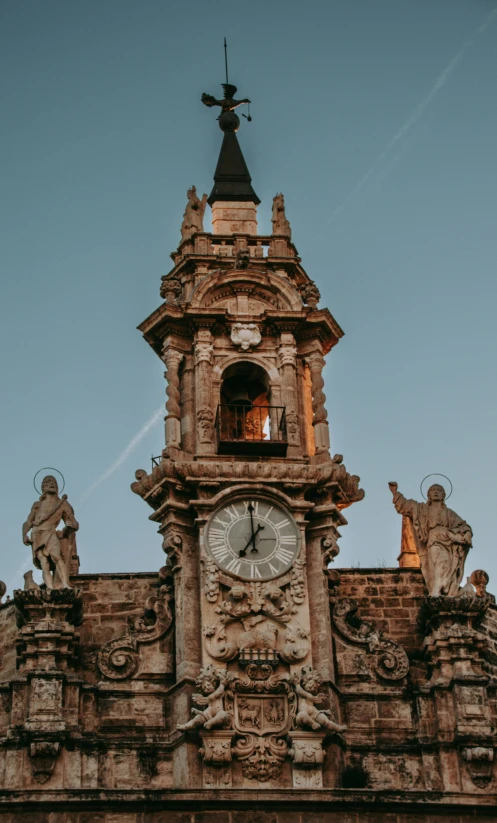 a very large brick building with a tower like structure and an astronomical dial on the top