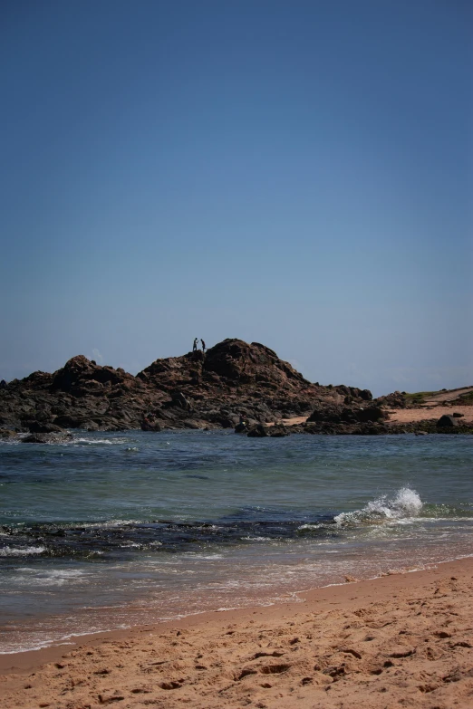 the view of an ocean and sand dunes from the beach