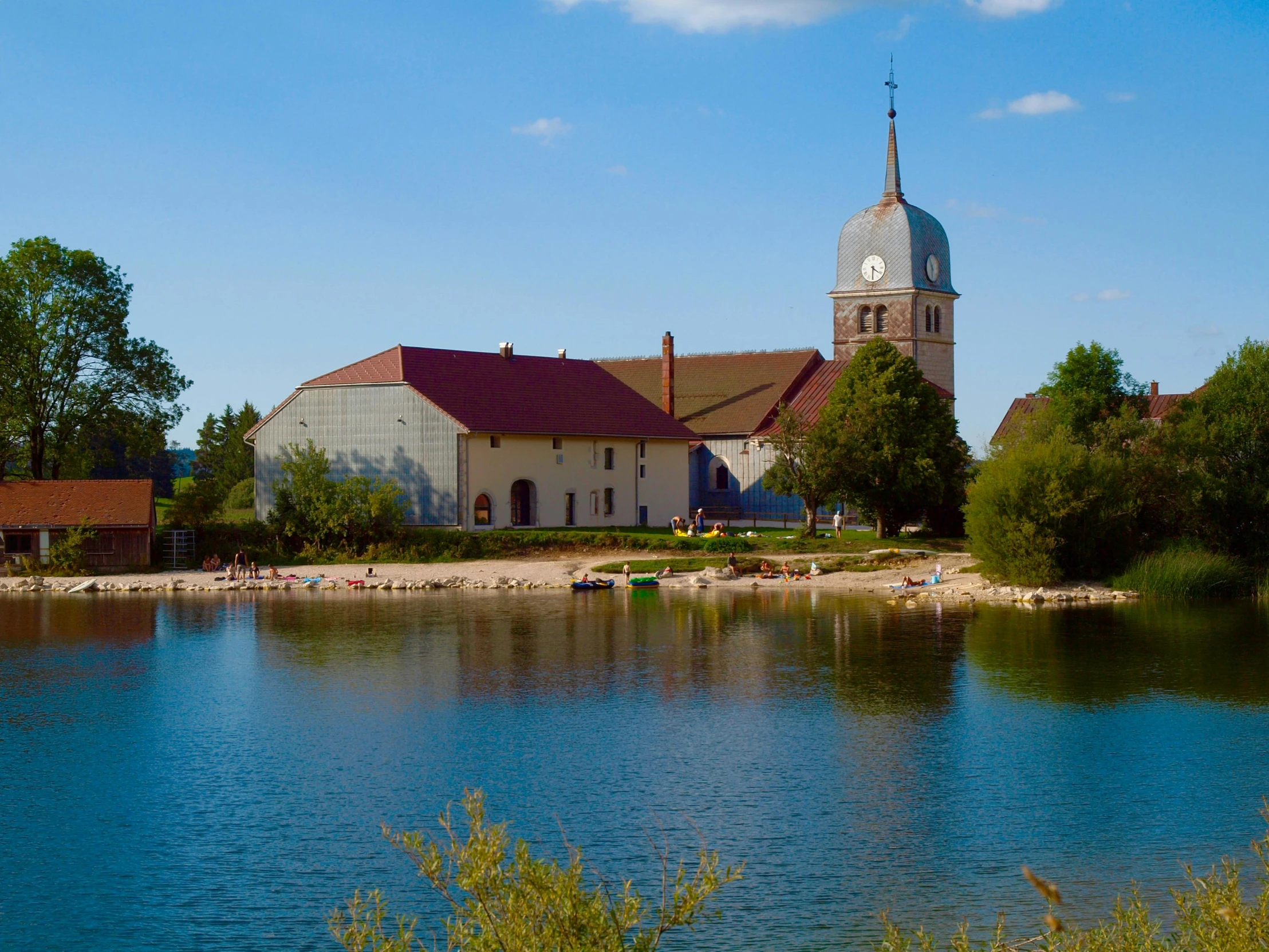 the building beside the water has a clock tower