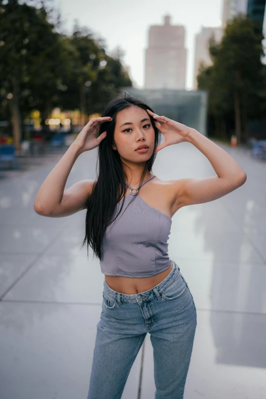 a girl stands in front of a fountain holding her head