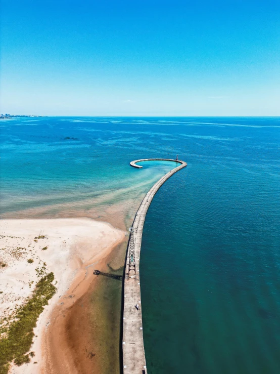 an island surrounded by the ocean in a blue sky