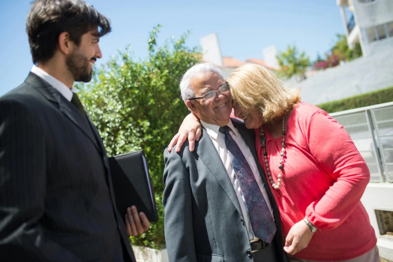 an older couple hugs as the woman holds a book