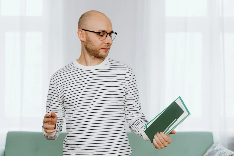 the man is holding some books while talking